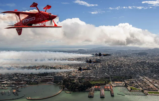 Team Oracle aerobatics pilot Sean D. Tucker flies above the US Navy Blue Angels over San Francisco, California as part of a practice run for Fleet Week on October 04, 2018. (Photo by Josh Edelson/AFP Photo)