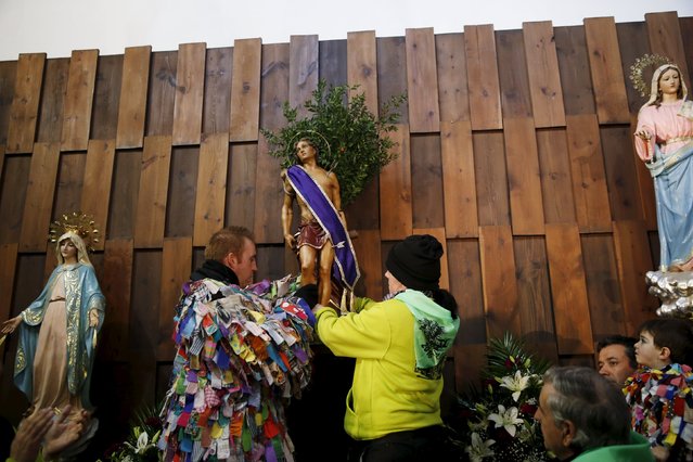 Jarramplas Armando Vicente Vicente, 30, and his sister Laura place a statue of Saint Sebastian at the altar during the Jarramplas traditional festival in Piornal, southwestern Spain, January 20, 2016. (Photo by Susana Vera/Reuters)