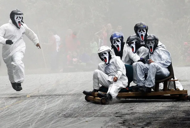 Participants descend a hill on a homemade roller cart during the 25th Roller Cart Festival in Medellin, October 27, 2013. (Photo by Albeiro Lopera/Reuters)