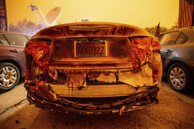 A scorched vehicle sits parked at a used car dealership after a wildfire burned through Paradise, Calif., on Friday, November 9, 2018. (Photo by Noah Berger/AP Photo)