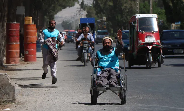 An Afghan man on a wheelchair joins on a “Peace Walk”, as they leave on a journey by foot to Kabul to cover a distance of around 1,800 Kilometers, calling an end to decades old war, in Herat, Afghanistan, 07 August 2018. They demanded the government and the Taliban to restore peace in the country. (Photo by Jalil Rezayee/EPA/EFE)
