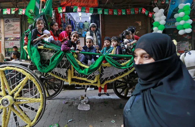 Children sit on a chariot as they attend a religious procession to mark Eid-e-Milad-ul-Nabi, or birthday celebrations of Prophet Mohammad, in the old quarters of Delhi, November 21, 2018. (Photo by Adnan Abidi/Reuters)