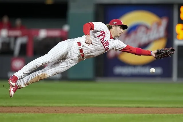 Philadelphia Phillies second baseman Bryson Stott misses a throw during the seventh inning in Game 1 of the baseball NL Championship Series against the Arizona Diamondbacks in Philadelphia, Monday, October 16, 2023. (Photo by Brynn Anderson/AP Photo)