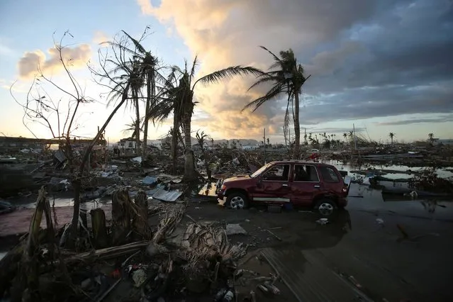 As the sun sets, it lights the sky over the area devastated by Typhoon Haiyan, in Tacloban, central Philippines, Friday, November 15, 2013. Typhoon Haiyan, one of the most powerful storms on record, hit the country's eastern seaboard November 8, leaving a wide swath of destruction. (Photo by Aaron Favila/AP Photo)