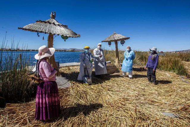 Health workers arrive to the Uros islands to inoculate citizens with a dose of the Sinopharm vaccine against COVID-19, in the Titicaca lake in Puno, Peru, on July 7, 2021. The vaccination campaign called “Vaccine Lake” was in charge of the Puno health network, and its main target was to inoculate citizens of the White Land island. (Photo by Carlos Mamani/AFP Photo)