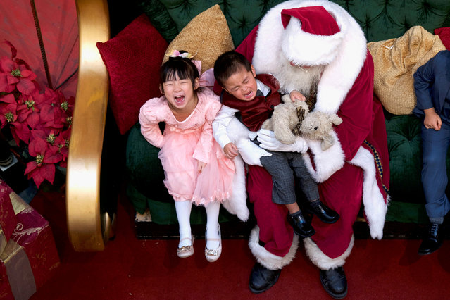 A girl laughs while her brother cries being held by Santa Claus at the King of Prussia Mall, in King of Prussia, Pennsylvania, U.S., December 8, 2018. (Photo by Mark Makela/Reuters)