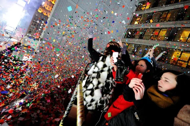 Revelers take photos and celebrate as confetti falls just after midnight during New Year celebrations in Times Square in New York, January 1, 2017. (Photo by Mark Kauzlarich/Reuters)