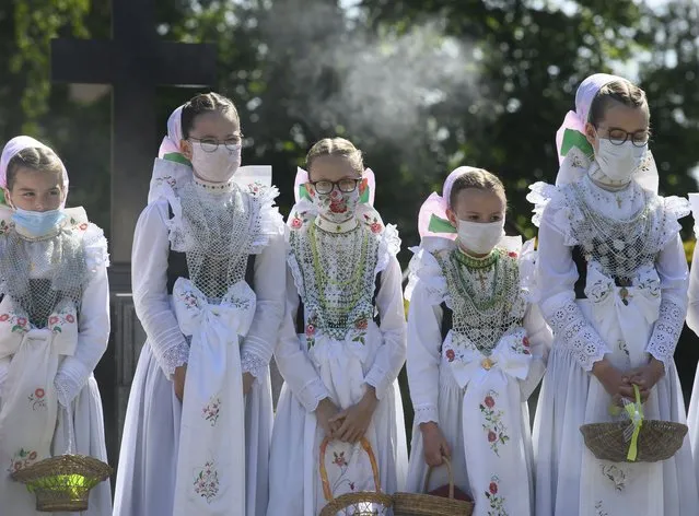 Sorbian bridesmaids in traditional costumes in a cemetery after a Corpus Christi liturgy in Crostwitz, Germany on June 3, 2021. (Photo by Robert Michael/AP Photo)