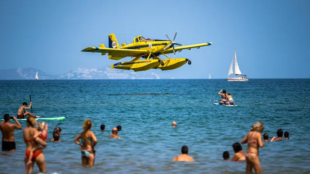 A seaplane being used to fight wildfires approaches to refill water off the beach of Oliva, in Valencia, Spain on August 14, 2022. (Photo by Sergio Porras via Reuters)