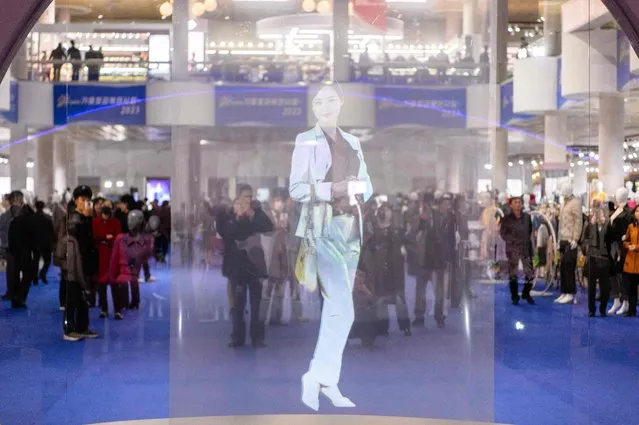 Visitors look at a digital hologram as they attend the opening of the 2023-Autumn Garment Exhibition at the Okryu Exhibition House in Pyongyang on November 9, 2023. (Photo by Kim Won Jin/AFP Photo)