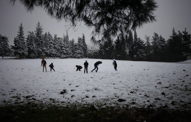 People play in a snow-covered field during a storm in Amman, Jordan on Thursday, December 12, 2013. Snow blanketed most regions of Jordan, blocking highways in the south, causing power cuts across the capital and closing down schools and government offices. (Photo by Mohammad Hannon/AP Photo)