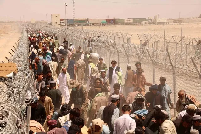 People stranded at the Pakistani-Afghan border wait to cross the border after it was reopened at Chaman, Pakistan, 13 August 2021. Pakistani authorities reopened the border with Afghanistan on 13 August after several days of its closure. Taliban’s shadow governor for Kandahar province had on 05 August issued a statement that announced the closing down of the border with Pakistan at Chaman, and said Islamabad should relax rules for crossing the frontier. (Photo by Akhter Gulfam/EPA/EFE)