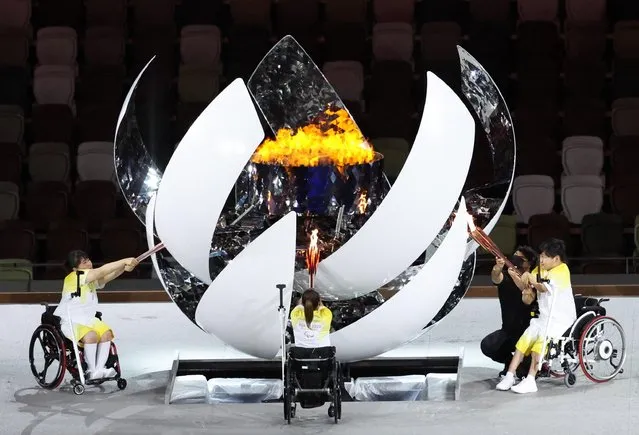 Yui Kamiji, Shunsuke Uchida and Karin Morisaki light the Paralympic flame during the opening ceremony of the Tokyo 2020 Paralympic Games at the Olympic Stadium on August 24, 2021 in Tokyo, Japan. (Photo by Ivan Alvarado/Reuters)