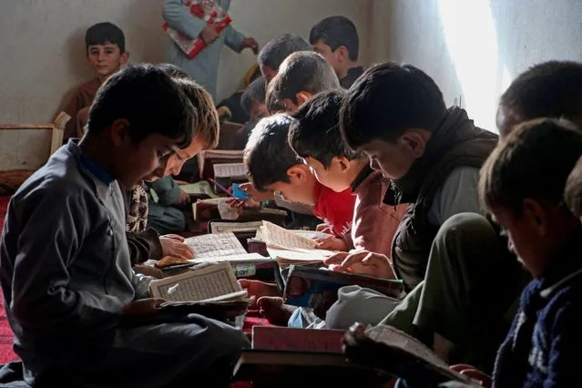 Afghan children read the holy Koran at a madrassa or an Islamic school in the Fayzabad district of Badakhshan province on November 20, 2023. (Photo by Omer Abrar/AFP Photo)
