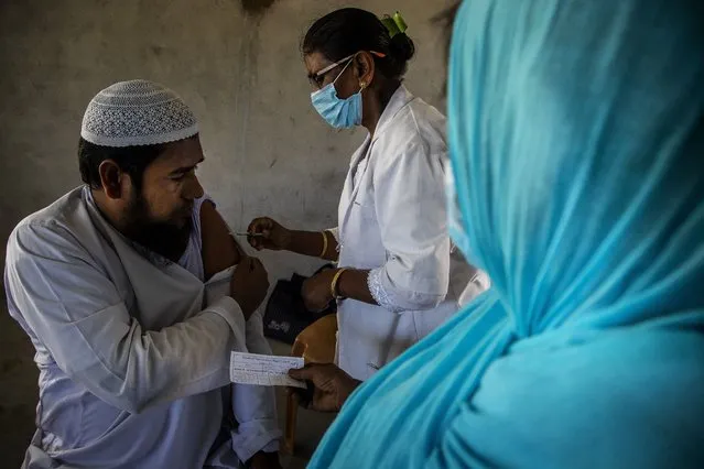 A health worker administers the vaccine for COVID-19 in Khola Bhuyan village on the outskirts of Gauhati, India, Tuesday, September 7, 2021. (Photo by Anupam Nath/AP Photo)
