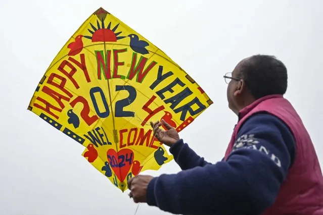 A man flies a decorated kite on the occasion of New Year's Eve in Amritsar on December 31, 2023. (Photo by Narinder Nanu/AFP Photo)