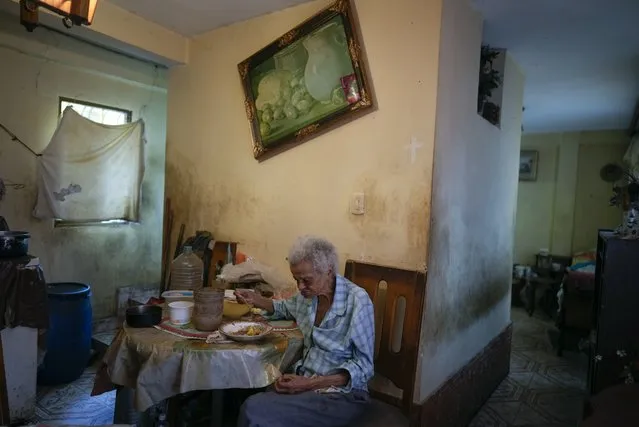 Zenobia Ansualve eats lunch at her home in Caracas, Venezuela, Wednesday August 18, 2021. The 88-year-old Ansualve, who lives alone and has not left her home since the start of the COVID-19 pandemic, said she lives on $20 a month from a room she owns and rents. (Photo by Ariana Cubillos/AP Photo)