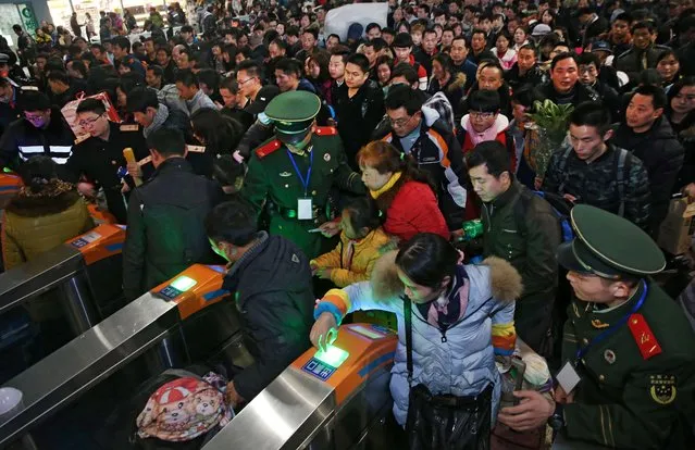 Chinese paramilitary guards monitoring passengers as they head to their train to travel to their hometowns for the “Spring Festival” or Lunar New Year at Nantong Railway Station in Jiangsu province, near Shanghai Travellers taking part in the world' s largest annual human migration must be home by January 27 to usher in the new year on January 28. (Photo by AFP Photo/Stringer)
