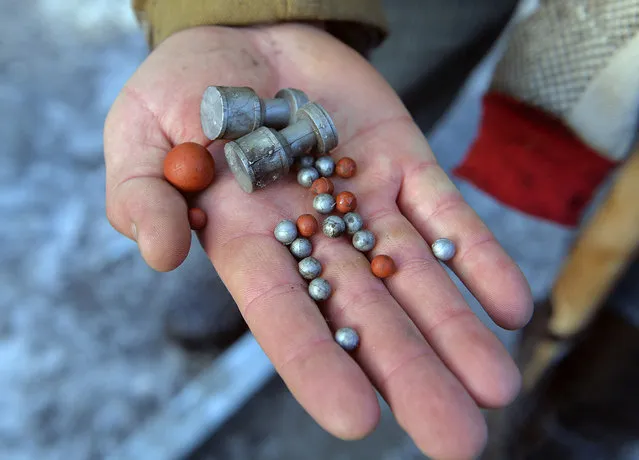A protester displays rubber bullets and pellets used by police during clashes with opposition demonstrators in the centre of the Ukrainian capital Kiev on January 20, 2014. EU foreign ministers on January 20 deplored violent protests in Kiev, saying the government was at fault for passing a package of repressive laws in an effort to tame pro-EU demonstrations. (Photo by Sergei Supinsky/AFP Photo)