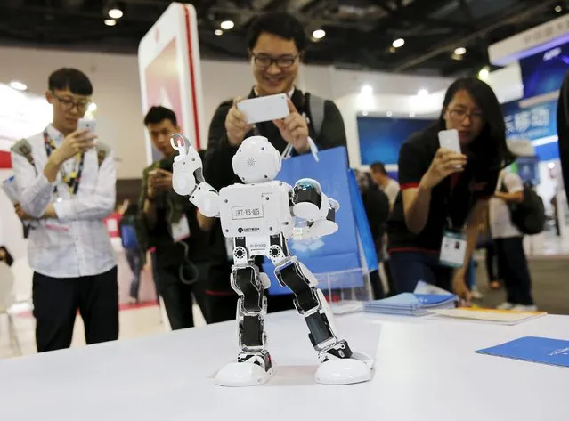 Visitors take pictures of humanoid intelligent robot Alpha developed by UBTECH at the Global Mobile Internet Conference (GMIC) 2015 in Beijing, China, April 28, 2015. (Photo by Kim Kyung-Hoon/Reuters)