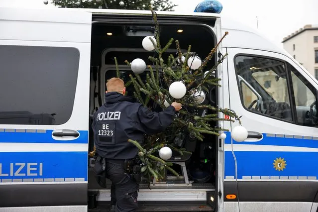 Members of the police load the top of the Christmas tree, which was cut off by “Letzte Generation” (Last Generation) activists, into a police vehicle at Brandenburg Gate, in Berlin, Germany on December 21, 2022. (Photo by Christian Mang/Reuters)