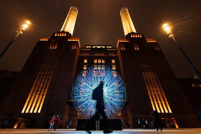 People walk past the light art installation titled “Singularity” by artist group Squidsoup as part of Battersea Power Station's annual Light Festival in London, Britain, 25 January 2024. The light trail has seven light art installations and it is free to visit from 25 January to 25 February 2024. (Photo by Tolga Akmen/EPA/EFE)