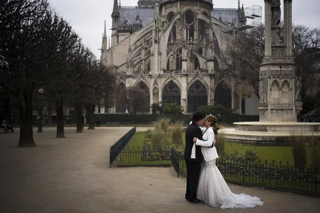 A couple kisses after renewing their vows behind Notre-Dame Cathedral in Paris on Valentine's Day, February 14, 2017. (Photo by Martin Bureau/AFP Photo)