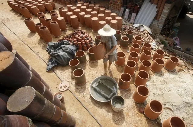 A man puts clay products to dry at a factory at Phu Lang pottery village in Bac Ninh province, Vietnam, May 14, 2015. (Photo by Reuters/Kham)