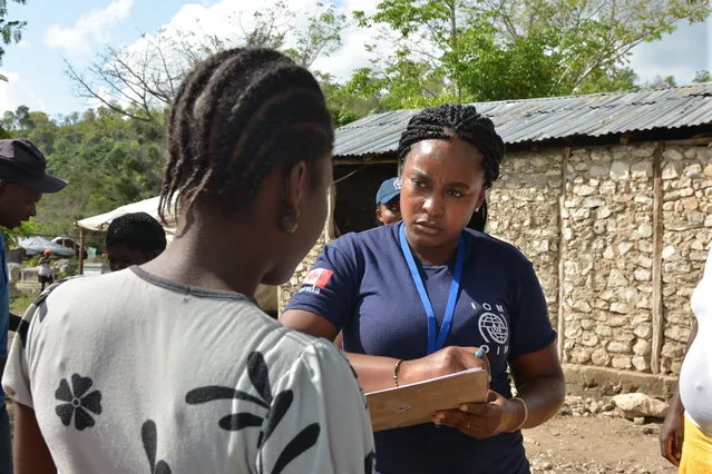 In this March 22, 2015 photo, Yvelaine Herisse of the International Organization for Migration takes notes while talking to a resident of an encampment outside the southeast Haitian town of Anse-a-Pitres. (Photo by David McFadden/AP Photo)