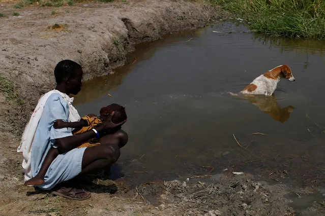 A woman washes her baby in a pond in Nimini village, Unity State, South Sudan February 8, 2017. (Photo by Siegfried Modola/Reuters)