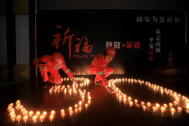 Firefighters take part in a candlelight vigil after a forest fire that broke out Saturday in Muli county, Sichuan province killed 30 firefighters, in Rongan county, Guangxi Zhuang Autonomous Region, China April 2, 2019. (Photo by Reuters/China Stringer Network)