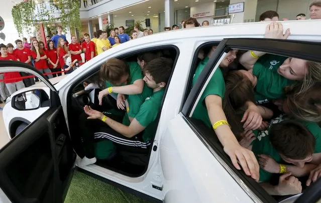 Students from the Siberian State Aerospace University team squeeze into a car during a local competition and attempt for a Guinness Book of World Records for the most number of people in a car in Krasnoyarsk, Russia, May 16. 2015. (Photo by Ilya Naymushin/Reuters)