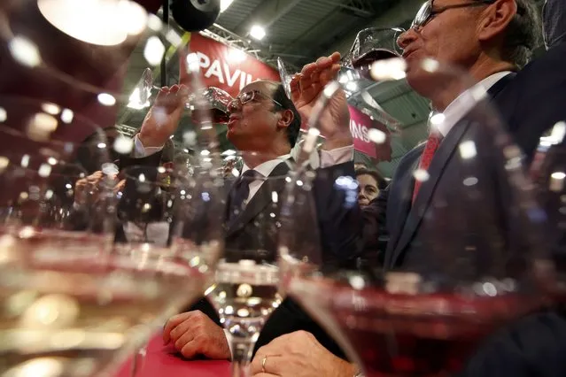 French President Francois Hollande (L) drinks a glass of wine as he visits the International Agricultural Show in Paris, France, February 25, 2017. The Paris Farm Show runs from February 25 to March 5, 2017. (Photo by Christian Hartmann/Reuters)