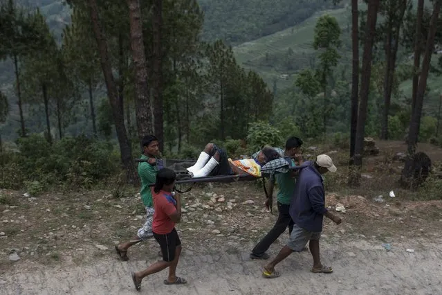 A victim who was injured in Tuesday's earthquake is carried by his relatives in Sindhupalchowk, Nepal, May 13, 2015. (Photo by Athit Perawongmetha/Reuters)