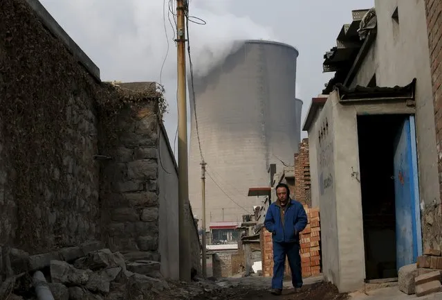 A man makes his way at a village which locates next to chimneys of coal-fired power plant in Shijiazhuang, Hebei province, China, January 28, 2015. (Photo by Kim Kyung-Hoon/Reuters)