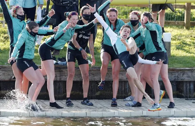 Cambridge women's cox Dylan Whittaker is thrown in The River Great Ouse as they celebrate winning the boat race against Oxford in Ely, United Kingdom on April 4, 2021. (Photo by Paul Childs/Pool via Reuters)