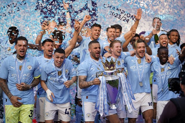 Manchester City's Kyle Walker celebrates with the Premier League trophy after the English Premier League soccer match between Manchester City and West Ham United at the Etihad Stadium in Manchester, England, Sunday, May 19, 2024. Manchester City clinched the English Premier League on Sunday after beating West Ham in their last match of the season. (Photo by Dave Thompson/AP Photo)