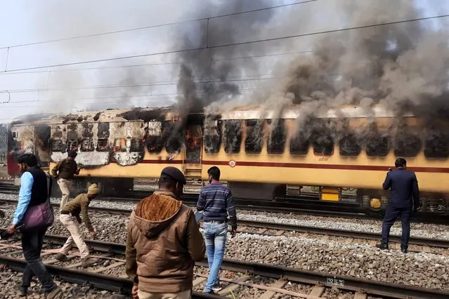 Smoke comes out from a train's carriage after angry mobs set it on fire in protests over access to railway jobs that have seen police violently disperse crowds with tear gas and baton charges, in Gaya, in the northeast Indian state of Bihar on January 26, 2022. (Photo by AFP Photo/Stringer)