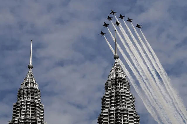 The South Korean Air Force “Black Eagles” aerobatic team flies past Malaysia's Petronas Twin Towers in Kuala Lumpur on March 29, 2017. (Photo by Manan Vatsyayana/AFP Photo)