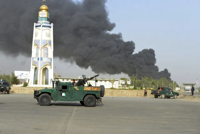 Afghan security forces arrive after a powerful explosion outside the provincial police headquarters in Kandahar province south of Kabul, Afghanistan, Thursday, July 18, 2019. A Taliban fighter in southern Kandahar province attacked the police headquarters with a car bomb, killing himself and at least nine others and wounding dozens more, officials said. (Photo by AP Photo/Stringer)