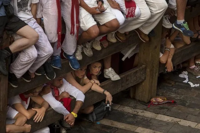 Revelers gather to watch Jandilla fighting bulls running at the San Fermin festival, in Pamplona, Spain, Tuesday, July 7, 2015. (Photo by Andres Kudacki/AP Photo)