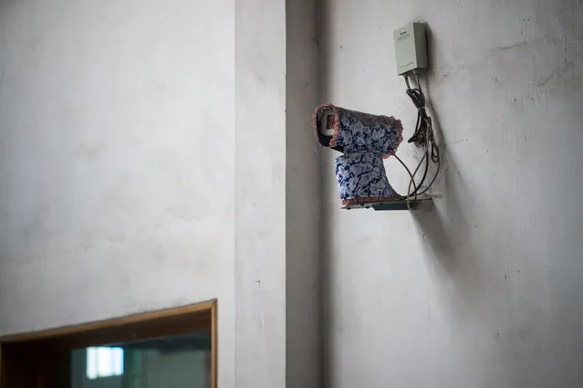 A security camera is seen covered in a floral drape during a media tour of the March 26 Electric Cable Factory in Pyongyang on May 6, 2016. When one of the world's most secretive states opens the door to the international media, it keeps a firm grip on the handle. Some 130 journalists flocked to North Korea at the express invitation of the Pyongyang authorities to cover the opening of a rare ruling party congress. They got within 200 meters of the venue, the April 25 Palace, and that was where they were stopped – on the other side of the road, under a steady drizzle that had been falling on the capital all morning. (Photo by Ed Jones/AFP Photo)