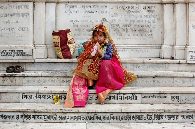 A girl dressed as Kumari, drinks as she sits on stairs after attending rituals to celebrate the Navratri Festival inside the Adyapeath Temple, on the outskirts of Kolkata, April 5, 2017. (Photo by Rupak De Chowdhuri/Reuters)