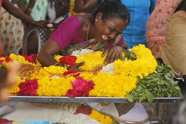 A relative of a man, who died after drinking illegally brewed liquor, cries over a casket containing his body, in Kallakurichi district of the southern Indian state of Tamil Nadu, India, Thursday, June 20, 2024. The state's chief minister M K Stalin said the 34 died after consuming liquor that was tainted with methanol, according to the Press Trust of India news agency. (Photo by R. Parthibhan/AP Photo)