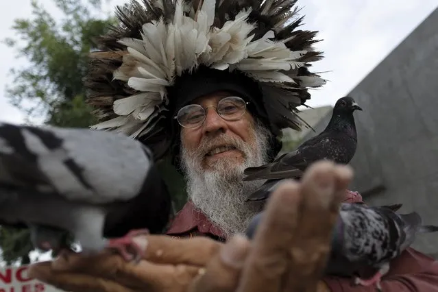 Jesus Moreno, 60, feeds pigeons in downtown Monterrey, Mexico July 7, 2015. For the past 30 years Moreno, who was once homeless, a drug addict, and formerly working as a investigative policeman, has been feeding pigeons twice a day, because to him they represent peace and the only way to communicate to God, local media reported. (Photo by Daniel Becerril/Reuters)