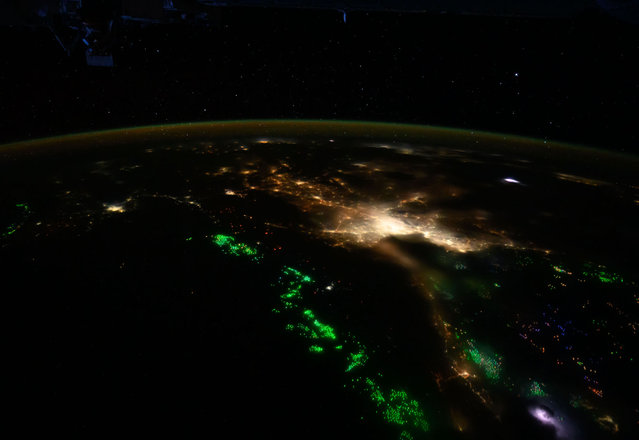 The city lights of Bangkok, Thailand, and its suburbs contrast with the green lights of fishing boats on the Gulf of Thailand and the Andaman Sea, seen on May 6, 2024. (Photo by NASA)