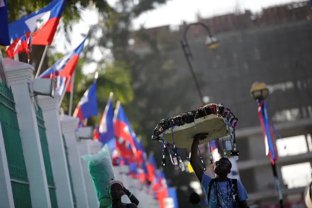A street vendor looks at Haitian flags set on a fence of the National Palace for the inauguration of President-elect Jovenel Moise in Port-au-Prince, Haiti, February 6, 2017. (Photo by Andres Martinez Casares/Reuters)