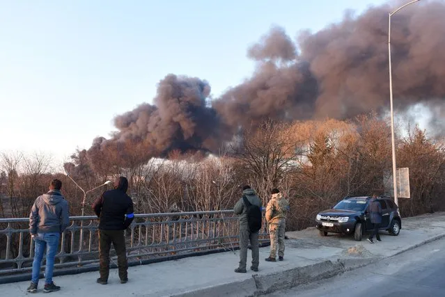 Smoke rises after an explosion in the western Ukrainian city of Lviv on March 18, 2022. Russian forces on March 18 destroyed an aircraft repair plant in the western Ukrainian city of Lviv but no one was hurt, the mayor said. Lviv is the largest city in western Ukraine and a popular tourist destination known for its picturesque views. Last weekend Russian cruise missiles devastated a military base west of Lviv, killing 35 people and wounding more than 130. Located 70 kilometres (45 miles) from the border with EU member Poland, the city had largely been spared since Russian forces invaded on February 24. (Photo by Yuriy Dyachyshyn/AFP Photo)