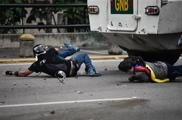 Opposition activists are run over by a charging National Guard riot control vehicle during a protest against Venezuelan President Nicolas Maduro, in Caracas on May 3, 2017. (Photo by Carlos Becerra/AFP Photo)