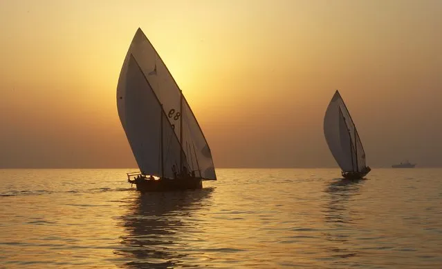 Traditional wooden boats, or dhows, compete at sunrise during the Al Gaffal race, a long-distance dhow sailing race, near Sir Bu Nuayr, near Sharjah May 18, 2014. (Photo by Martin Dokoupil/Reuters)